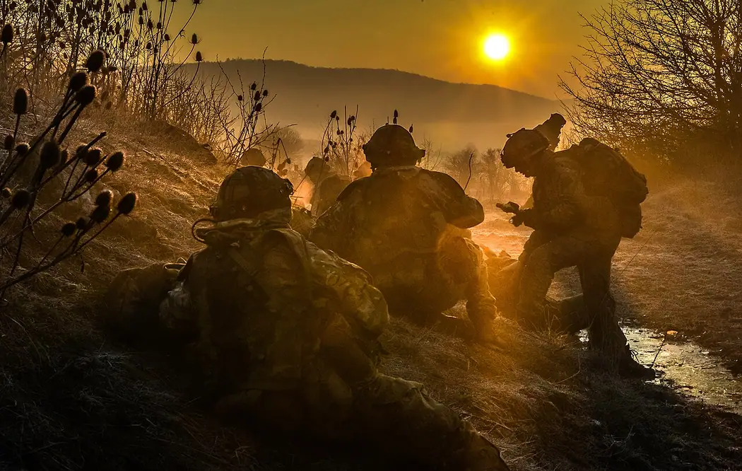 Army officer cadets on a field exercise silhouetted at sunrise